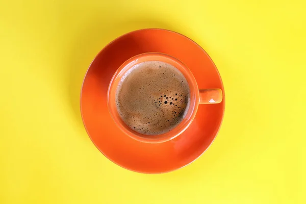 黄色の背景のカップでコーヒー トップビュー — ストック写真