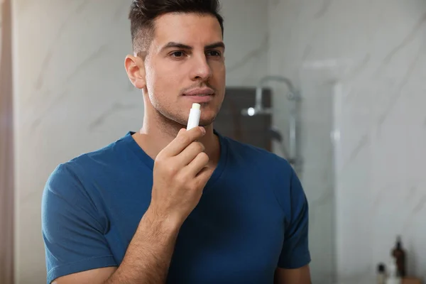 バスルームで衛生的なリップバームを適用する男 — ストック写真