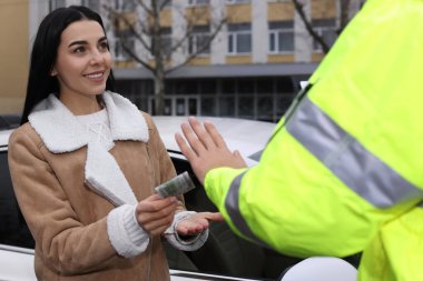 Polis memuru dışarıda arabanın yanında rüşvet vermeyi reddediyor.