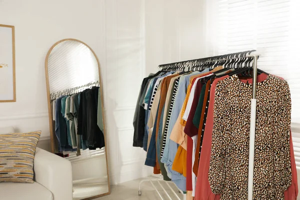 Cremalheira Com Roupas Elegantes Perto Sofá Espelho Dentro Casa Moda — Fotografia de Stock