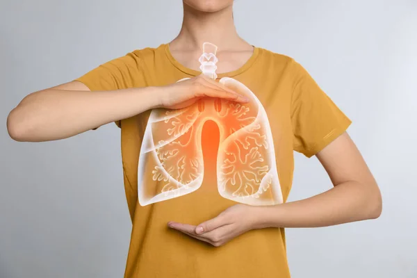 ライトグレーの背景に肺のイラストと胸の近くに手を保持女性 クローズアップ — ストック写真