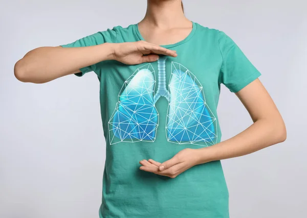 ライトグレーの背景に肺のイラストと胸の近くに手を保持女性 クローズアップ — ストック写真