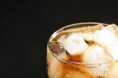 Siyah arka planda buz küpleriyle serinletici bir içecek, yakın plan