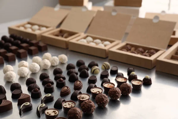 Verschiedene Leckere Schokoladenbonbons Und Schachteln Auf Weißem Tisch Produktionslinie — Stockfoto