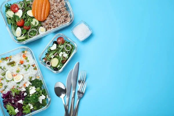 Açık mavi zemin üzerinde taze yiyecek ve çatal bıçak takımı olan cam kaplar. Metin için boşluk