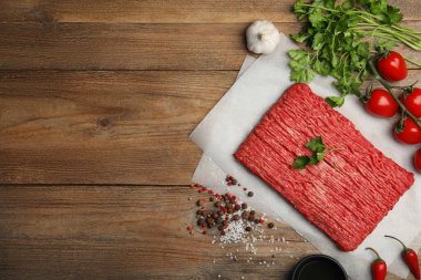 Çiğ taze kıyma, domates ve ahşap masa üzerindeki diğer malzemeler, düz yatak. Metin için boşluk