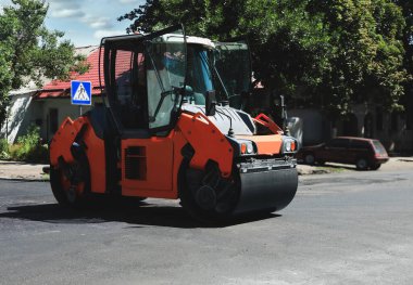 Şehir caddesinde çalışan bir patenci. Yol onarımı