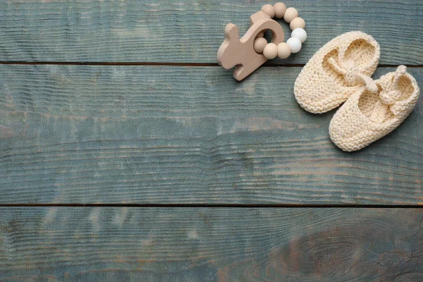可爱的婴儿靴和玩具在浅蓝色的木制背景上 案文的篇幅 — 图库照片