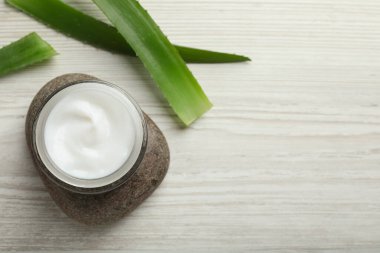 Bir kavanoz organik krema, spa taşı ve beyaz ahşap masa üzerinde aloe, düz uzanmış. Metin için boşluk