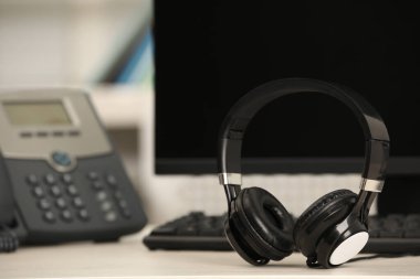 Modern kulaklıklar, masaüstü telefon ve bilgisayar kapalı masa, metin için boşluk
