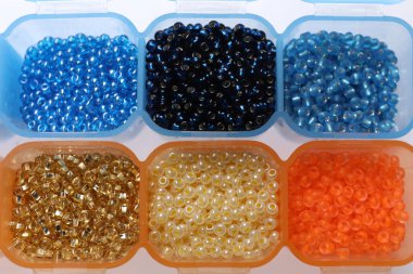 Beyaz arkaplanda farklı boncuklara sahip plastik organizatörler, üst görünüm
