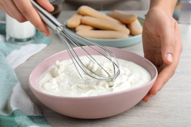 Beyaz ahşap masada tiramisu keki yapan kadın, yakın plan.