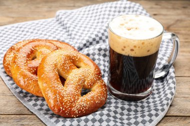 Lezzetli krakerler ve ahşap masada bir bardak bira.