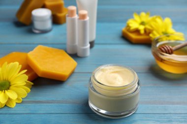 Mavi ahşap masada doğal balmumu bileşenli krema.