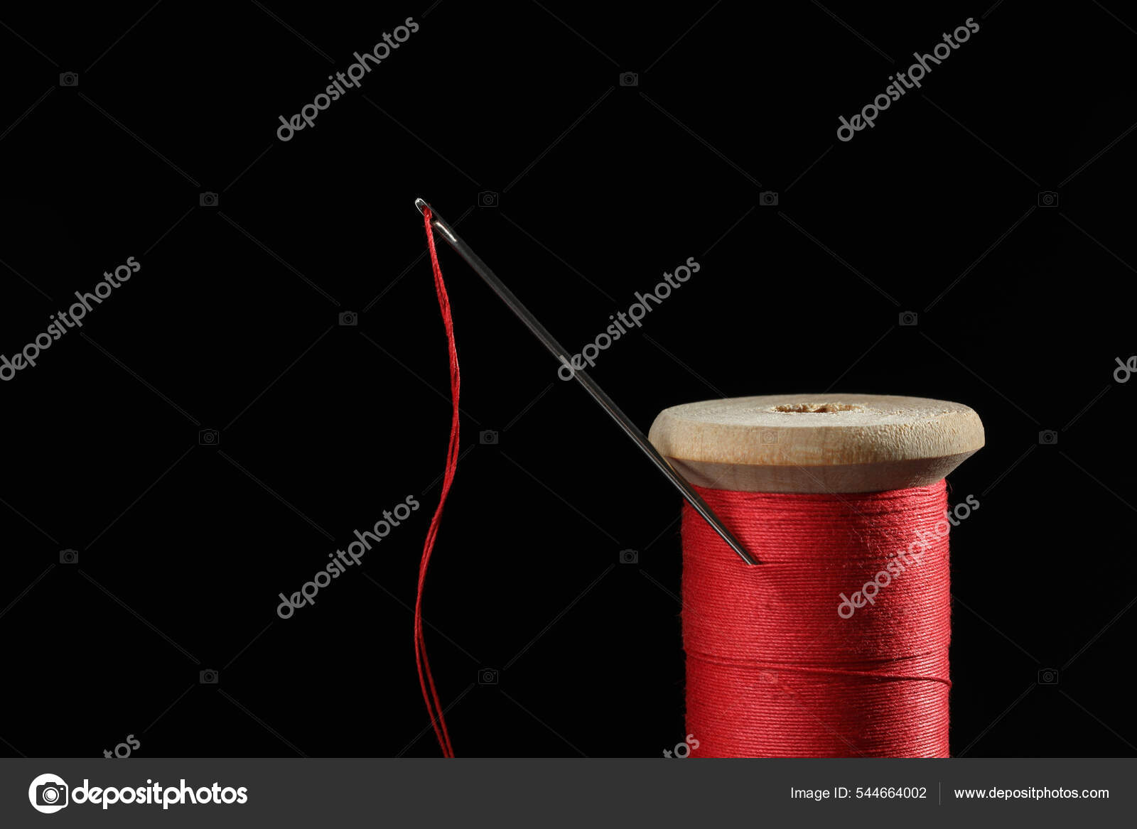 Black Thread on an Old Wooden Spool and Sewing Needle Stock