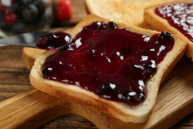 Ahşap masada sunulan reçelli lezzetli tost, yakın plan.