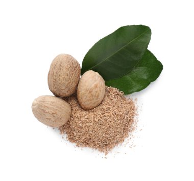Nutmeg tozu ve yeşil yapraklı tohumlar beyaz arkaplanda, üst görünüm