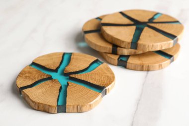 Beyaz masadaki ahşap bardak altlıkları.