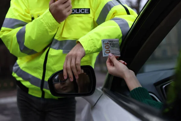 Kobieta Dająca Łapówkę Policjantowi Przez Okno Samochodu Zbliżenie — Zdjęcie stockowe