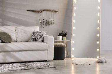 Ampullü şık bir ayna ve oturma odasında rahat bir kanepe. İç tasarım