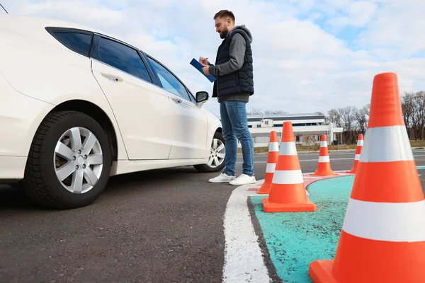 Instruktör Med Urklipp Nära Bilen Utomhus Låg Vinkel Körskoleprov — Stockfoto