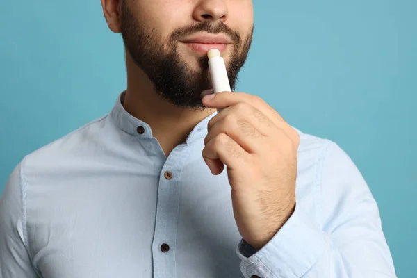 Jovem Aplicando Bálsamo Labial Fundo Turquesa Close — Fotografia de Stock