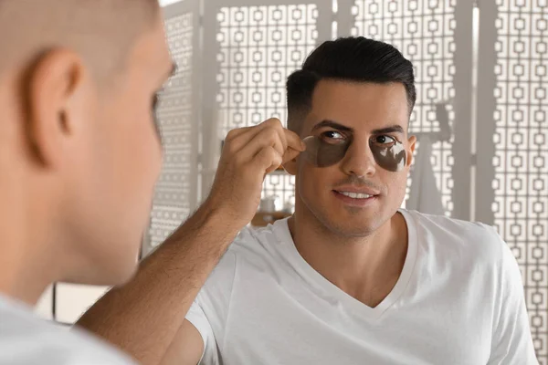 Man Applying Dark Eye Patch Mirror Home — Stock Photo, Image