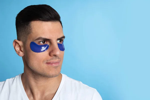 Hombre Con Parches Debajo Los Ojos Sobre Fondo Azul Claro —  Fotos de Stock