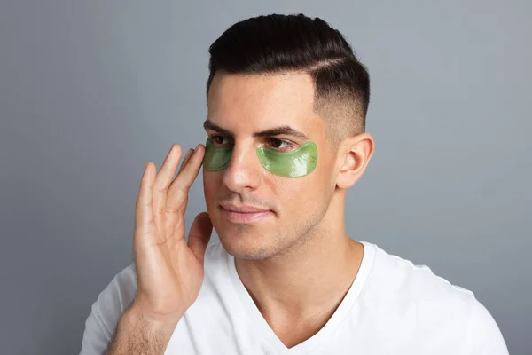 Man Applying Green Eye Patch Grey Background — Stock Photo, Image