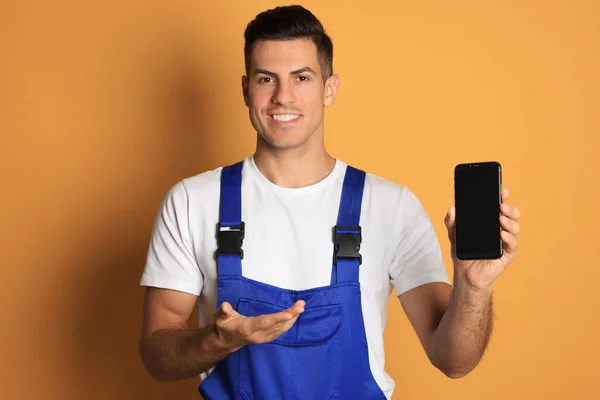 Reparador Com Smartphone Moderno Fundo Laranja — Fotografia de Stock