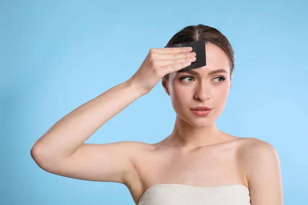 Hermosa Mujer Usando Mattifying Toallita Sobre Fondo Azul Claro — Foto de Stock