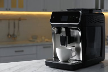Mutfaktaki beyaz tezgahlı modern elektrikli kahve makinesi.