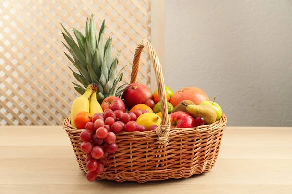 Wicker Korg Med Olika Färska Frukter Träbord — Stockfoto