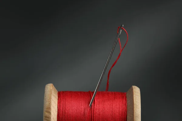 濃い背景に針で赤い縫製糸 クローズアップ — ストック写真