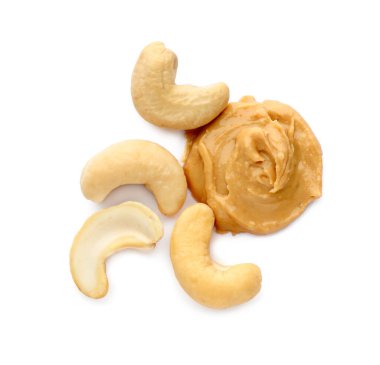 Beyaz arka planda kremalı kaju ezmesi ve fındık.