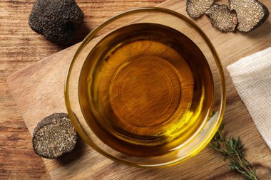 Taze trüf mantarı, kekik ve cam kasedeki yağ ahşap masada, düz yatıyordu.