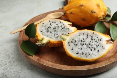 Lezzetli kesilmiş ahşap tabak ve tüm ejderha meyveleri (pitahaya) masada, yakın plan