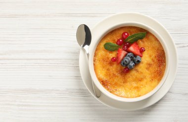 Beyaz ahşap masa üzerinde taze böğürtlenli nefis krema brulee, üst manzara. Metin için boşluk