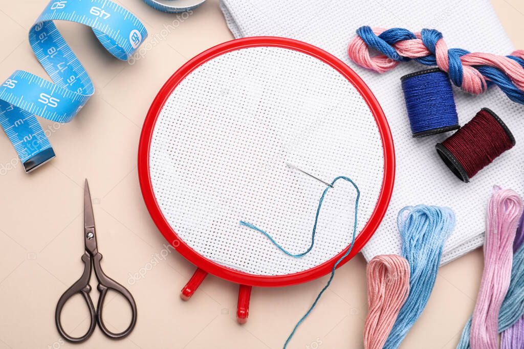 Flat lay composition with embroidery hoop on beige background