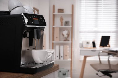 Modern espresso makinesi ofiste fincana kahve dolduruyor. Metin için boşluk
