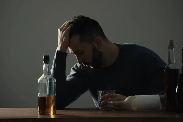 Verslaafde Man Met Drank Aan Houten Tafel Binnen — Stockfoto