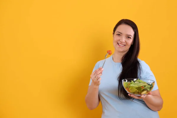 Hermosa Mujer Con Sobrepeso Comiendo Ensalada Sobre Fondo Amarillo Espacio — Foto de Stock