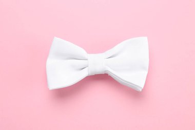 Pembe arka planda şık beyaz papyon, üst manzara