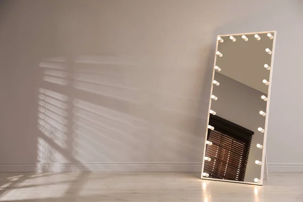 白い壁の近くに電球が室内でスタイリッシュなミラー 内装要素 — ストック写真