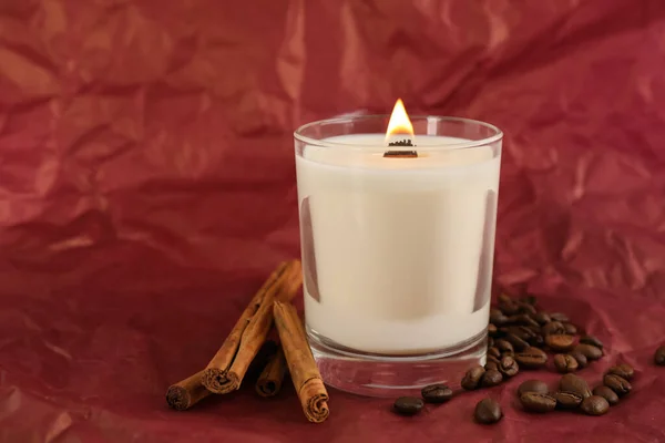 Brennende Sojakerze Zimtstangen Und Kaffeebohnen Auf Zerknülltem Rotem Papier Platz — Stockfoto