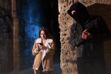 Silahlı bir suçlu, duvarın arkasında saklanıyor ve gece sokakta kurbanı bekliyor.