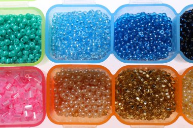 Beyaz arkaplanda farklı boncuklara sahip plastik organizatörler, üst görünüm