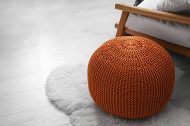 Odanın zemininde şık örülmüş bir puf. İç tasarım
