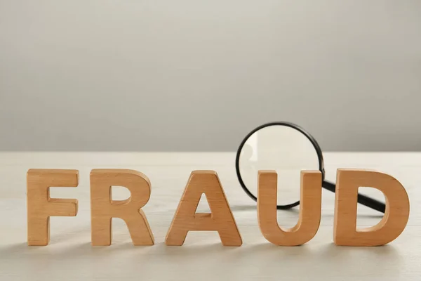 Word Fraud Made Wooden Letters Magnifying Glass White Table Space — Stock Photo, Image