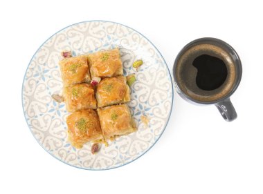 Fıstıklı enfes baklava ve beyaz arka planda sıcak kahve.